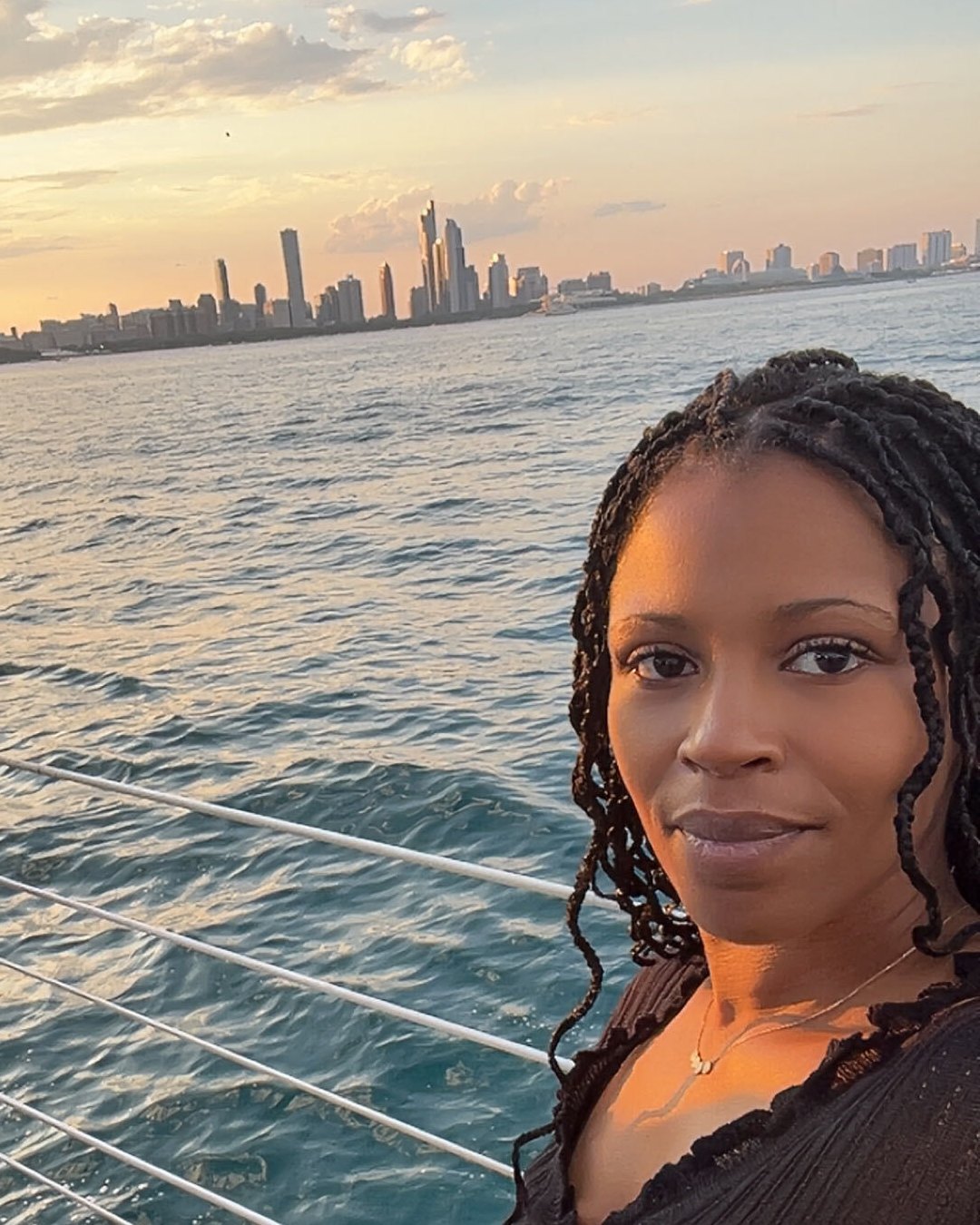 Crystal Boyd on a boat on the water, with a city skyline in the distance